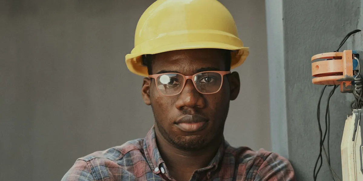 An engineer in a yellow hard hat and glasses on site